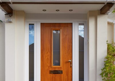 Coombe Oak Composite door with white sidelights, chrome pad handle and architectural letterplate