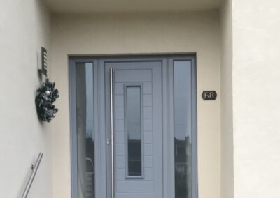 Elephant grey Fuji Composite door with matching sidelights and 1800 long bar handle, fitted in Broadstone